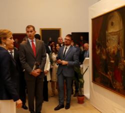 Sus Majestades los Reyes contemplan una de las obras expuestas en la exposición